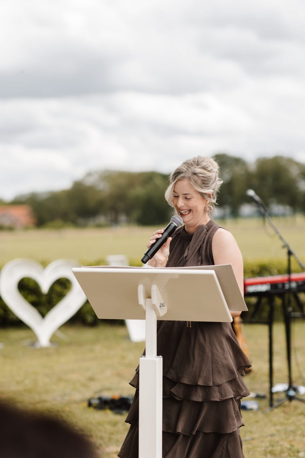 Nadhie achter de lessenaar tijdens een ceremonie in de buitenlucht