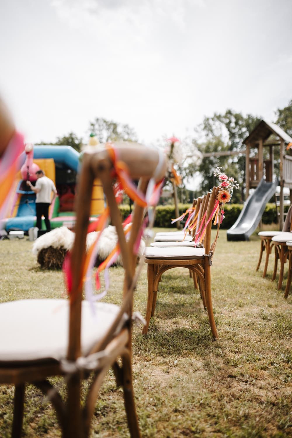 Rijen stoelen met kleurrijke linten op het gras